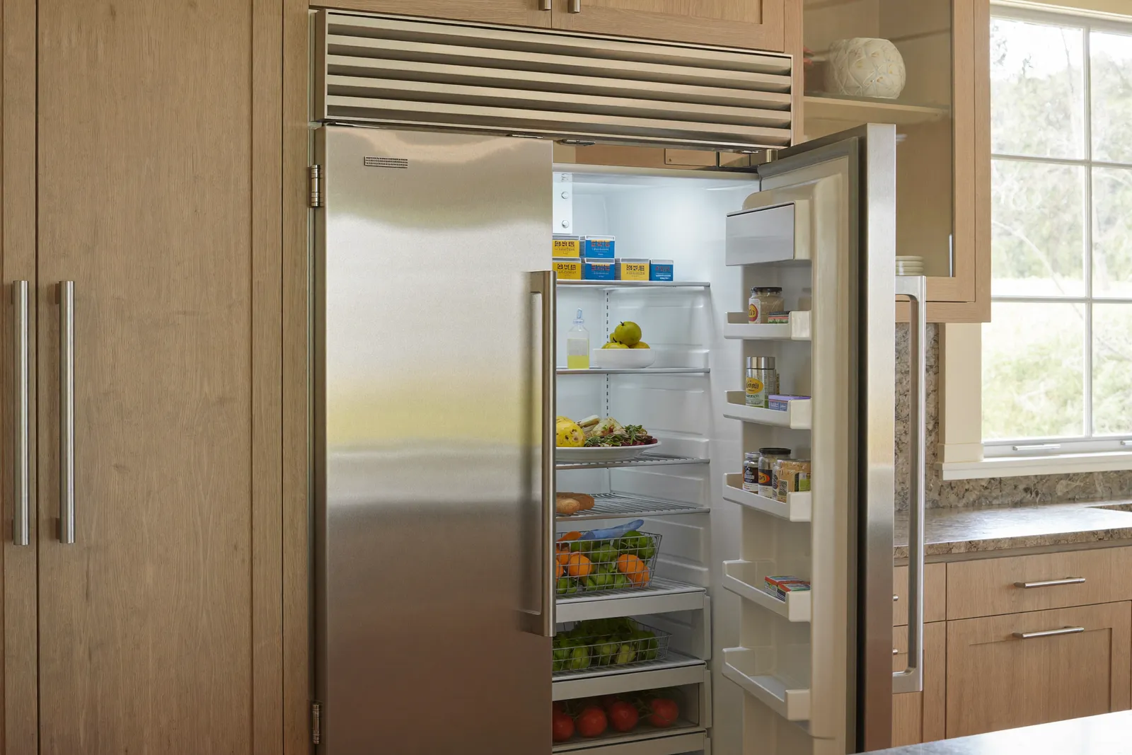 An open built-in stainless refrigerator in a kitchen